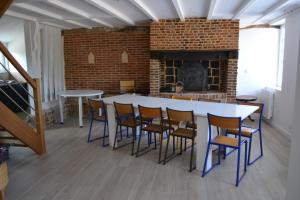 DoudevilleLa clef des champs的客房设有桌椅和壁炉。