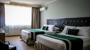 塔尔卡Ecohotel Talca的酒店客房设有两张床和窗户。