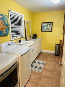 维洛海滩Comfy Beach House on Vero Beach的黄色的厨房,配有水槽和镜子