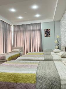 库塔伊西Hotel Rustaveli的配有粉红色窗帘的客房内的两张床