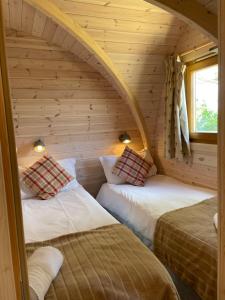 LeightonRabbit Glamping Pod School House Farm的小木屋内带两张床的房间