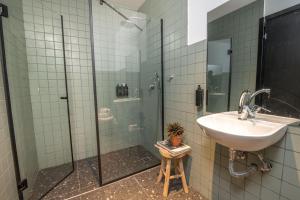 特拉维夫Selina Tel Aviv Beach的一间带水槽和玻璃淋浴的浴室