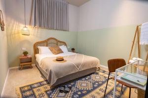 特拉维夫Selina Tel Aviv Beach的一间卧室,配有一张床,上面有帽子