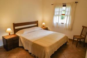 多拉杜Hotel Fazenda Bela Vista的一间卧室配有一张床、两盏灯和一个窗户。