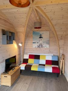 LeightonHedgehog Glamping Pod School House Farm的木制客房内的一间卧室,配有一张床