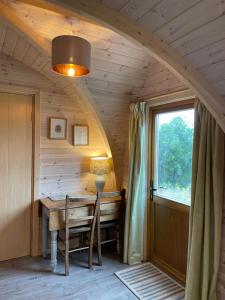 LeightonHedgehog Glamping Pod School House Farm的一间拱形客房,位于一个小房子内,配有一张桌子