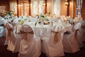 斯特金贝The Lodge at Leathem Smith的一间设有白色布艺椅子的桌子的房间