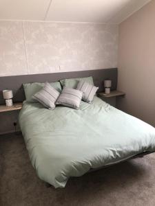米勒姆Tranquility No 42 Port Haverigg Marina的卧室内的一张带枕头的大床