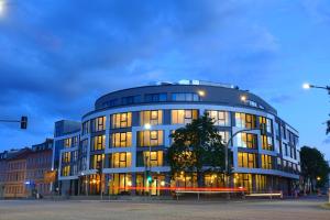 柏林附近贝尔瑙H24 Stadthotel Bernau的城市街道上一座拥有许多窗户的大型建筑