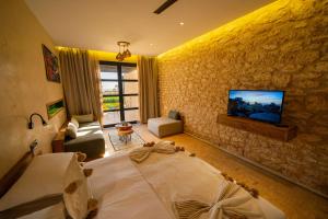 索维拉BABERRIH Hôtel Hospitality Palaces & Resorts的一间卧室配有一张床,墙上配有电视