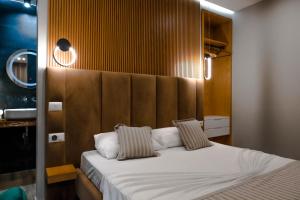 博尔什Luna Mare Seaside Suites的一间卧室配有一张大床和木制床头板
