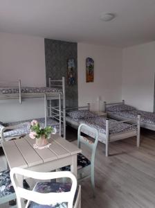 Henryków LubańskiDom Mili的客房设有三张双层床和一张桌子及椅子。