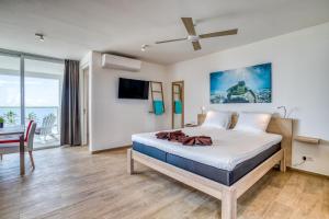 克拉伦代克Chogogo Dive & Beach Resort Bonaire的一间卧室配有一张床,另一间用餐室配有桌子