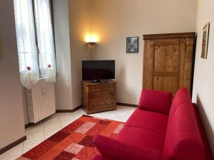 帕代诺杜尼亚诺Appartamento “Liberty”的客厅配有红色沙发和电视