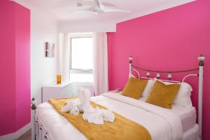 黄金海岸Beachfront Romantic Getaway - Surfers Paradise的粉红色的卧室,配有带毛巾的床