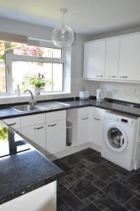 WestcottCheerful 3 bedroom property set in the countryside的厨房配有洗衣机、水槽和洗衣机。