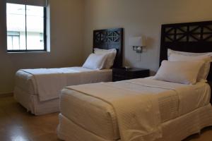 埃尔巴列德安通Paseo Suites El Valle, Luxury Apartments的一间卧室设有两张床和窗户。