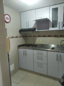 波哥大Mirador del parque的厨房配有白色橱柜、水槽和炉灶。