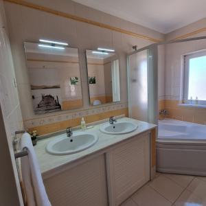 拉戈斯Casa Dos Cedros的浴室配有2个盥洗盆和1个浴缸。