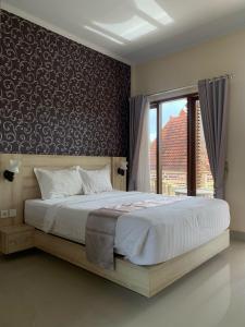 DalungNorth Wing Canggu Resort的一间卧室设有一张大床和一个窗户。