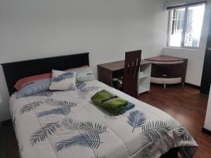 伊瓦拉Zidko Guest House的一间卧室配有一张大床、一张桌子和一把椅子