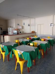 派桑杜洛巴托酒店的一间食堂,配有桌椅和绿色及黄色的桌子
