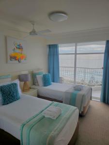 黄金海岸伯利冲浪公寓酒店的酒店客房设有两张床和窗户。