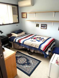 布里斯班Hill Haven的一间卧室配有两张床、一张桌子和一张地毯。