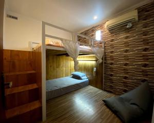 姆杜克Dong Paloh Hostel的一间卧室设有双层床和砖墙