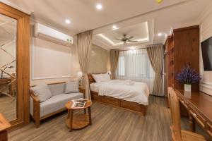 胡志明市Woody House Boutique的一间卧室配有一张床、一张沙发和一张桌子