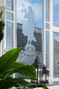维也纳凯瑟霍夫温酒店的窗户上拿着鲜花的女人的雕像