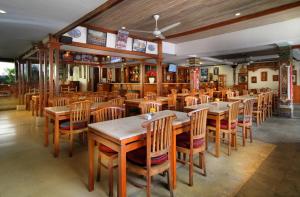 勒吉安巴厘岛拉玛花园酒店的用餐室配有木桌和椅子