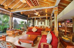 勒吉安巴厘岛拉玛花园酒店的客厅配有红色的沙发和桌子
