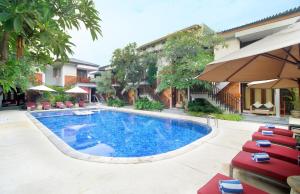 勒吉安巴厘岛拉玛花园酒店的一座带椅子的游泳池以及一座建筑