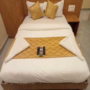 孟买Hotel New Sarah Inn, Andheri West的一张床上有手机的床