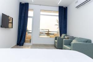 Campاستراحة نادي اورجان Orjan Guest House的带沙发和椅子的客厅以及窗户。