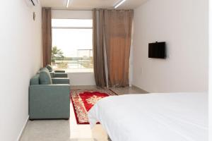 Campاستراحة نادي اورجان Orjan Guest House的一间卧室配有一张床、一张沙发和一个窗口
