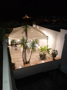 马蒂诺vacanza nel salento1的庭院在晚上种有盆栽植物和遮阳伞