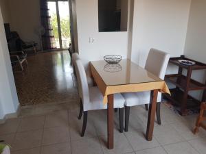 凯法利尼亚岛Filippos Apartments "Apartment 1"的餐桌、白色椅子和木桌