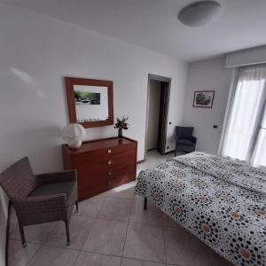 萨罗Appartamento GIRASOLE, Salò的一间卧室配有一张床、梳妆台和椅子