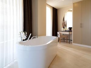 锡德Liu Resorts的浴室配有白色浴缸及桌子