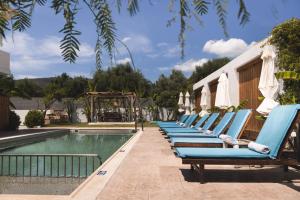 MouzákionBruma Luxury Residence的游泳池旁的一排蓝色躺椅