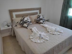 圣卡洛斯拉腊皮塔Els Pilanets的一张带白色床单和枕头的床
