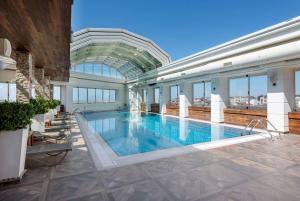 伊斯坦布尔Ramada Plaza By Wyndham Istanbul City Center的一座带玻璃天花板的大型游泳池