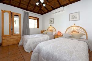 蒂哈拉费Casa Maryluna的一间卧室配有两张床和镜子