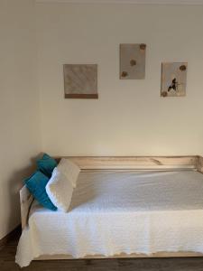 科英布拉Deluxe Studio com terraço e varanda privada - 'Casinha da Amoreira' Guesthouse的卧室内的一张床铺,墙上有两张照片