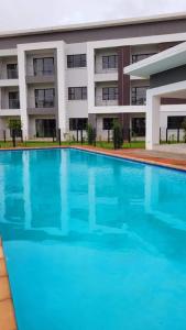 哈博罗内Sarona city Habitat Alpha apartments C202 Gaborone的大楼前的大型游泳池