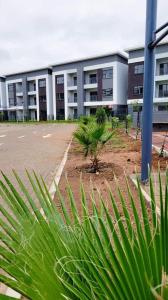 哈博罗内Sarona city Habitat Alpha apartments C202 Gaborone的一座大型建筑,前面设有停车场