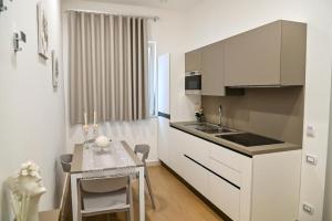 庞贝Floris Pompei的厨房配有白色橱柜、餐桌和用餐室