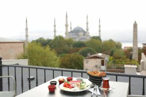 伊斯坦布尔HaciBayramHotel的阳台上的一张桌子上放着两盘食物